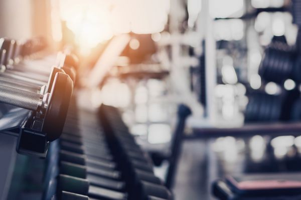 Attain apartment homes with A row of dumbbells in a gym with sunlight streaming through the windows in the background.
